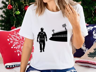 Police officer walking towards stadium with bright floodlights at night