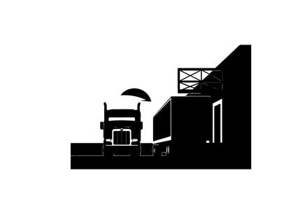 Truck silhouette parked beside a warehouse at sunset