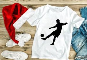 Silhouette of a soccer player kicking a ball in mid action
