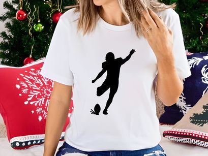 Silhouette of a soccer player kicking a ball in mid action