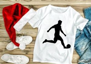 Silhouette of a soccer player kicking a ball in motion