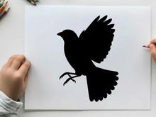 Silhouette of a bird in flight with outstretched wings and legs