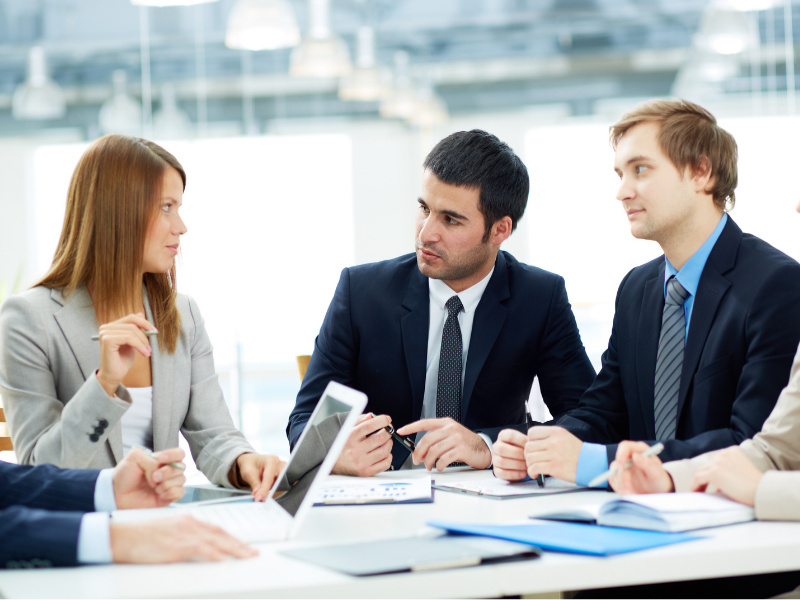 Professionals in formal attire engaged in a business meeting