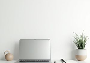Minimal desk workspace with laptop, notebook, and indoor plant