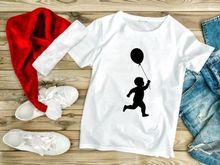 Silhouette of a toddler boy running with a balloon