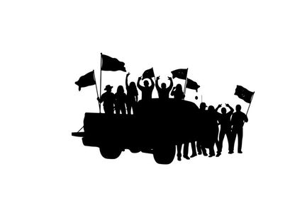 Silhouette of people on a truck waving flags in celebration