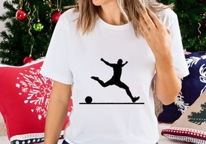 Silhouette of a soccer player kicking a ball in mid air motion