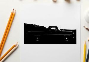 Silhouette of a classic pickup truck in front of a mountain range silhouette