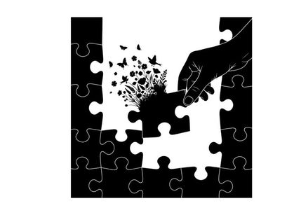 Silhouette of hand placing puzzle piece with butterflies and flowers emerging