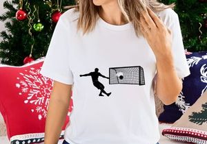 Soccer player kicking a ball into a goal