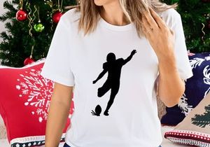 Silhouette of a soccer player kicking a ball in mid action