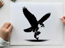 Silhouette of a bird of prey swooping down to catch a fish