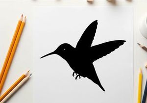 Silhouette of a hummingbird in flight against a white background