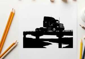Silhouette of a semi truck driving across a bridge