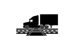 Silhouette of a semi truck on railroad tracks