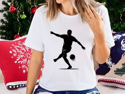 Silhouette of a soccer player kicking a ball in mid action