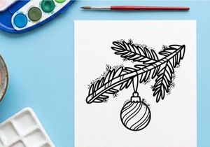 Hiasan Natal buatan tangan tergantung dari ranting pinus dengan pola garis-garis meriah