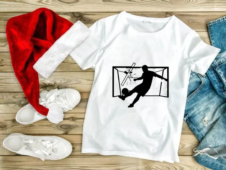 Soccer player kicking ball into goal with outstretched arms in mid air motion