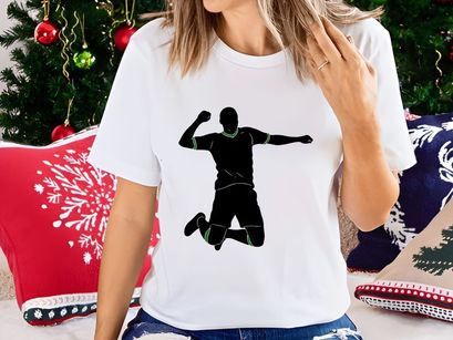 A silhouette of a man jumping in the air with his arms outstretched and fist raised