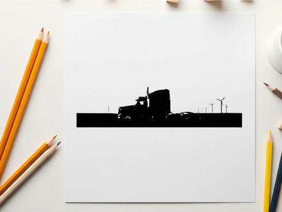 Silhouette of a semi truck driving on a road with wind turbines