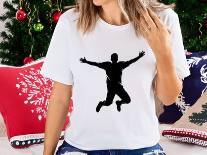 A silhouette of a man jumping in the air with arms outstretched and legs bent