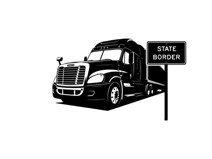 Black silhouette semi truck passing state border sign