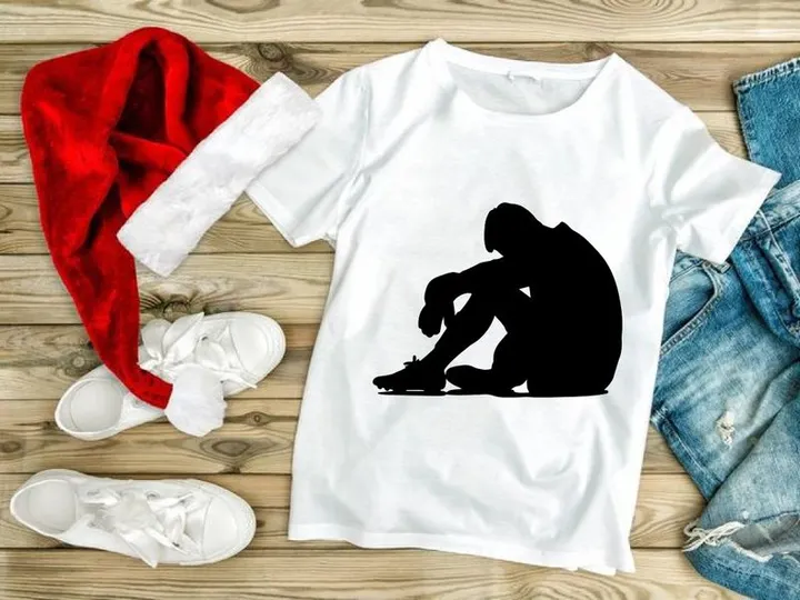A person sitting alone in a state of sadness or despair on the floor