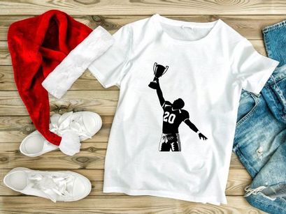 Victorious football player holding trophy in air with number 20 jersey