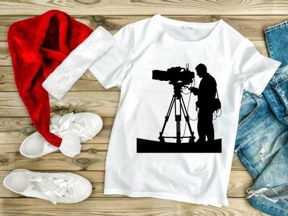 Silhouette of a cameraman operating a large video camera on a tripod stand