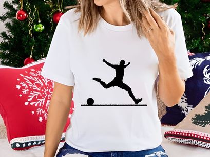 Silhouette of a soccer player kicking a ball in mid air motion