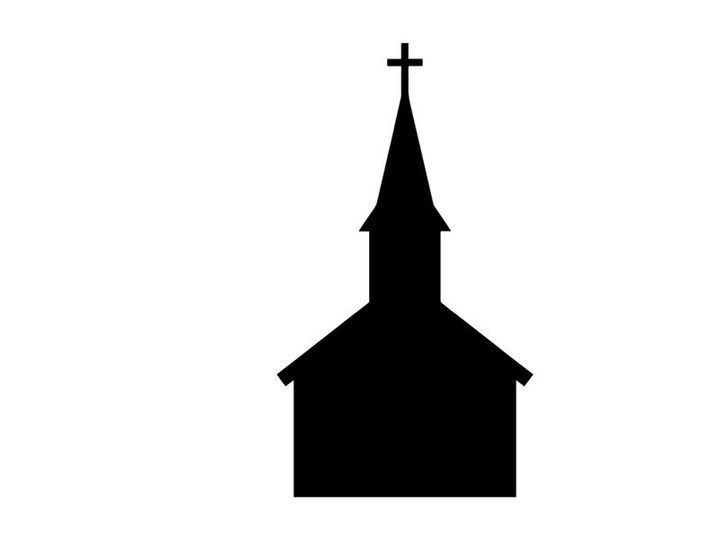 Silhouette of a church steeple with cross at sunset