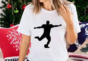 Silhouette of a soccer player kicking a ball in mid action