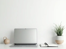 Minimal desk workspace with laptop, notebook, and indoor plant