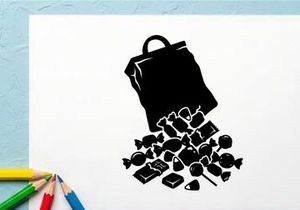 Silhouette of a spilled bag of chocolates and candies on white background