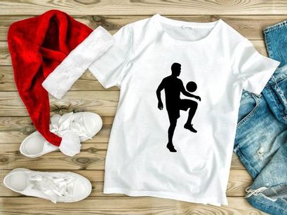 Silhouette of a man kicking a soccer ball in mid air motion