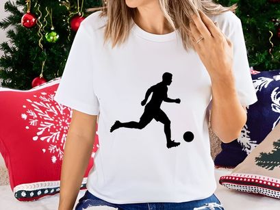 Silhouette of a soccer player kicking a ball in motion