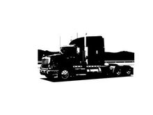 Silhouette of a semi truck on the road with mountains in the background