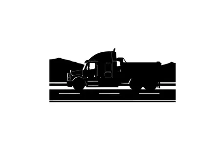 Silhouette of a large truck driving on a road with mountains