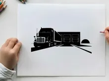 Silhouette of a semi truck driving into a warehouse at night