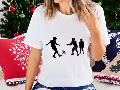 Silhouette of three boys playing rugby with a ball on a field