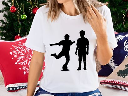 Two black silhouettes of boys playing soccer on a white background