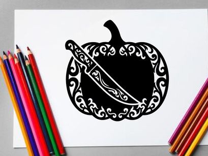 Silhouette of a pumpkin with a decorative carved design and a knife