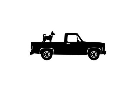 Silhouette of a dog riding in the back of a pickup truck