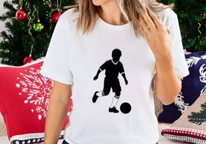 Silhouette of a boy playing soccer with a ball on a white background