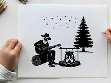 Silhouette of man playing guitar by campfire at night