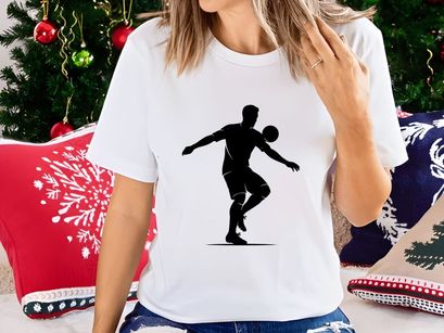 Silhouette of a soccer player kicking a ball in mid air motion