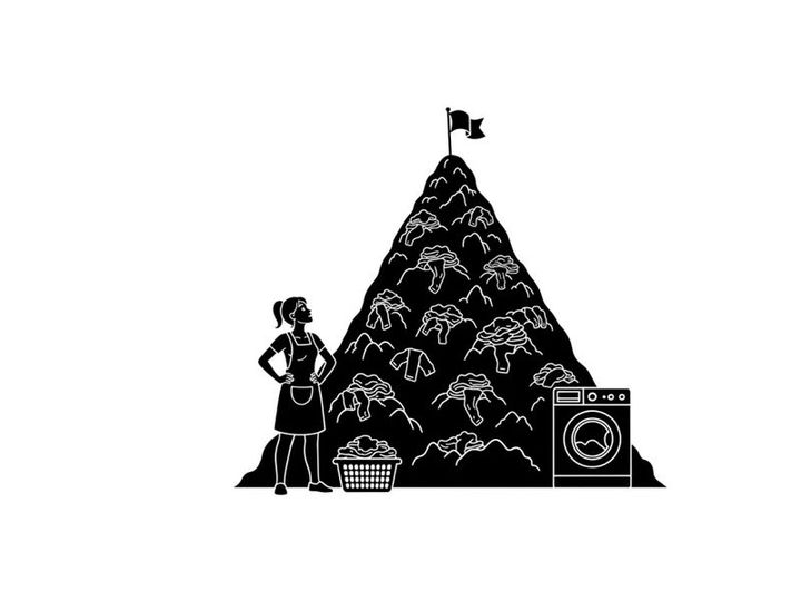 Silhouette of a woman standing beside a gigantic pile of laundry