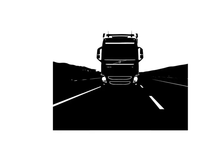 Silhouette of a large truck driving on a highway