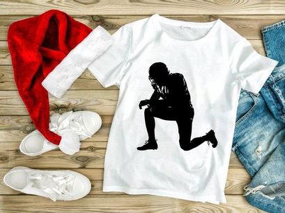 American football player in a kneeling position on the field in black silhouette