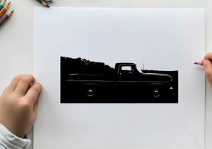 Silhouette of a classic pickup truck in front of a mountain range silhouette